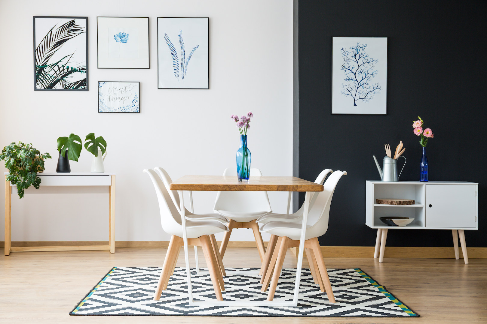 Wooden table with flowers standing on black and white carpet